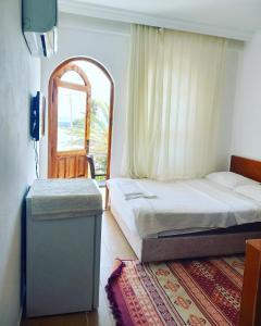 a bedroom with a bed and a window and a door at Hotel Anadolu in Finike