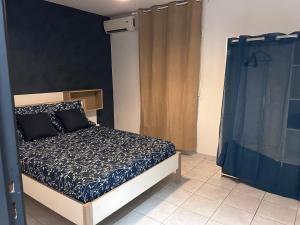 - une chambre avec un lit et un rideau bleu dans l'établissement T2 de standing bourg de Kourou, à Kourou