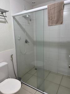 a bathroom with a glass shower with a toilet at Flat B306 Village Aldeia das Águas in Barra do Piraí