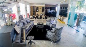 a living room with a couch and chairs in a room at Hotel Mansão Marcieri in Aquiraz
