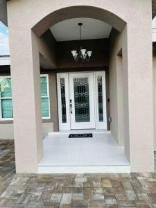 a front porch of a house with a white door at Charming Luxury House in Largo