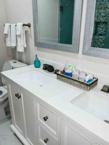 a white bathroom with a sink and a mirror at Charming Luxury House in Largo