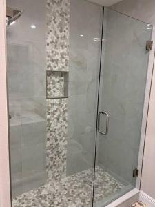 a shower with a glass door in a bathroom at Charming Luxury House in Largo