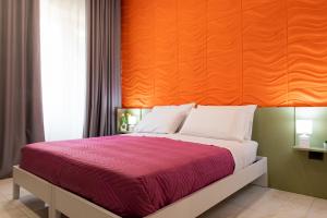 una camera con un grande letto con testiera arancione di May Flower Luxury a Napoli