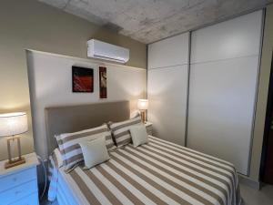 een slaapkamer met een bed met een gestreepte sprei bij Confortable y Equipado depto en Salta in Salta