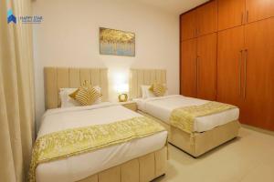 a bedroom with two beds and a cabinet at Spacious 2BR near MOE - 2 Min Drive in Dubai