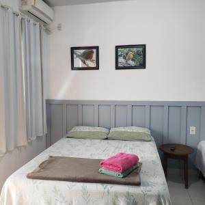 um quarto com uma cama com um cobertor rosa em Pousada Canto Dos Passaros em Pirenópolis