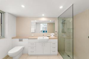 een badkamer met een toilet, een wastafel en een douche bij Maison Noosa in Noosa Heads