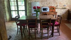 a kitchen with a wooden table with chairs and a refrigerator at Beautiful Stone Country Villa in Casaprota