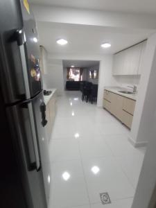 a kitchen with a refrigerator and a white floor at Hermosa casa en Medellin. Cerca a estación del metro in Medellín