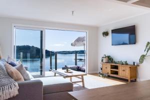 a living room with a view of the water at Sunshine Rise, Upstairs Unit, Romantic, Waterfront Retreat in Raglan