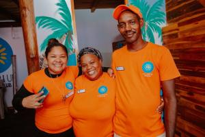 three people wearing orange shirts posing for a picture at Solarium Beach Club in Playa Blanca