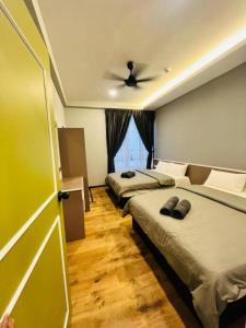 1 dormitorio con 2 camas y ventilador de techo en LAVIE HOTEL & APARTMENT en Brinchang