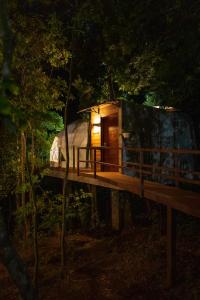 a tree house in the woods at night at Chira Glamping Monteverde in Monteverde Costa Rica
