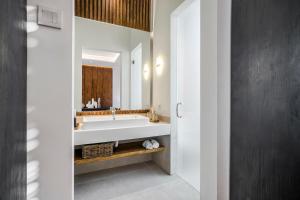 ein Badezimmer mit Waschbecken und großem Spiegel in der Unterkunft Priviere Luxury Villa - Canggu in Canggu + 32 Fotos