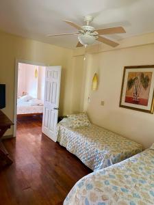 a bedroom with two beds and a ceiling fan at Lands End in West End