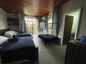 a bedroom with two beds and a room with windows at Sarah's Place San Andres in San Andrés