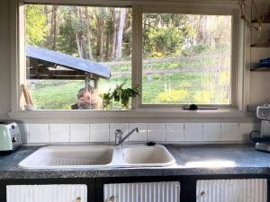 un lavandino con finestra in cucina di The Cloud House Hampton - Rustic Alpine Retreat a Lowther
