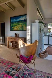 una sedia in soggiorno con un dipinto sul muro di The Cloud House Hampton - Rustic Alpine Retreat a Lowther