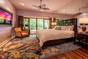 a bedroom with a large bed and a chair at MAKENA SURF, #C-205 condo in Wailea