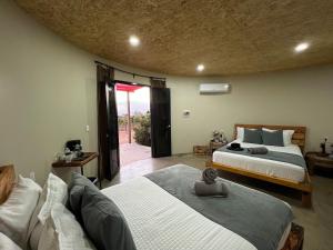 a bedroom with two beds and a couch in it at Don Tomas Viñedo cabañas in Valle de Guadalupe