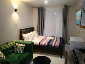 Habitación pequeña con cama y sofá en Valley Escapes Homes, en Kiambu