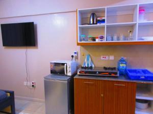 a kitchen with a microwave and a refrigerator at Valley Escapes Homes in Kiambu