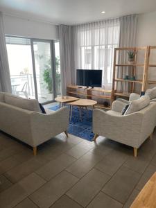 uma sala de estar com dois sofás e uma televisão em Waterfront 209 em Paihia