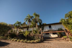 een huis met palmbomen ervoor bij Hotel Villa Deifiori in Bento Gonçalves