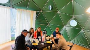 Un groupe de personnes assises à une table en train de manger dans l'établissement Sky Lodge Domes Salkantay, à Soray