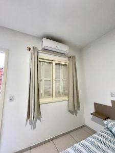 een slaapkamer met een raam met airconditioning bij Res Hostel 01 in Santa Cruz do Sul