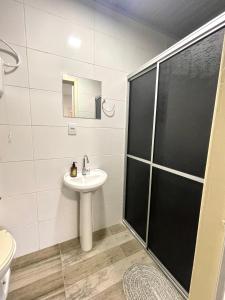 uma casa de banho com um lavatório e um chuveiro em Res Hostel 01 em Santa Cruz do Sul
