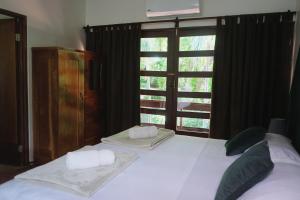 a bedroom with a large white bed with a window at Hotel Villa Del Sol in Coco