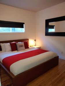 a bedroom with a large bed with red and white pillows at Cribs on the Hill in Picton