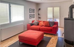 sala de estar con sofá rojo y reposapiés rojo en 2 Bedroom Gorgeous Home In Mlers, en Målerås
