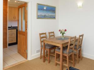 cocina y comedor con mesa de madera y sillas en Mulberry Cottage - Uk45432, en Isle of Whithorn