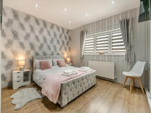 1 dormitorio con 1 cama y 1 silla blanca en Cherrytrees, en Scarborough