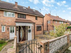 una casa de ladrillo con una puerta blanca y una valla en Cherrytrees, en Scarborough