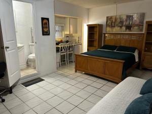 a bedroom with a bed and a bathroom with a kitchen at COZY QUEEN BED STUDIO NEAR DOLPHIN MALL-FIU in Miami