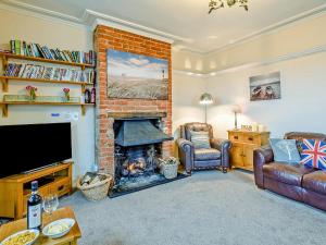 a living room with a fireplace and a couch at Beach House in Sea Palling