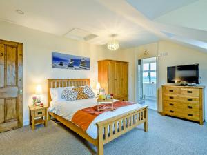 a bedroom with a large bed and a television at Beach House in Sea Palling