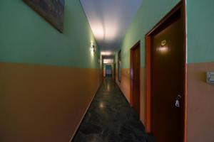 a hallway with a long corridor with green and brown walls at Collection O Hotel Blue Bird in Jaipur