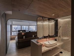 a bathroom with a sink and a large mirror at Hillwood House Hotel in Hong Kong