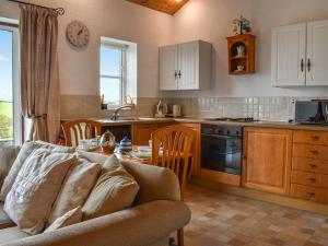 a kitchen with a couch and a table in a room at Mount Cottage in Wennington