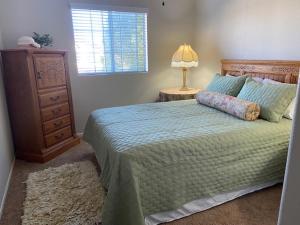 a bedroom with a bed with a lamp and a dresser at Luxury Wine Paradise 5Bd House-Murrieta CA in Murrieta