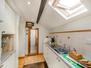 a kitchen with a sink and a skylight at Ty Canol in Llanfaelrhys