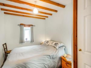 a small bedroom with a bed and a window at Ty Canol in Llanfaelrhys