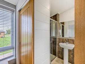 ein Bad mit einem Waschbecken und einem Spiegel in der Unterkunft Billy Goat Lodge in Crossway Green