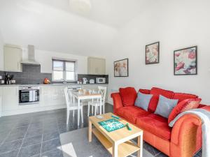 a living room with a red couch and a table at Overshot - Uk45388 in Crewkerne
