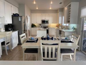 a kitchen with a table and chairs and a kitchen with white cabinets at Luxury Wine Paradise 5Bd House-Murrieta CA in Murrieta
